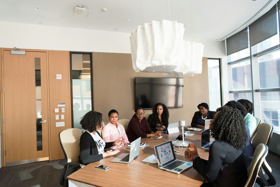 Colleagues seated around a boardroom table in discussion, illustrating on-site interpretation in a professional setting.